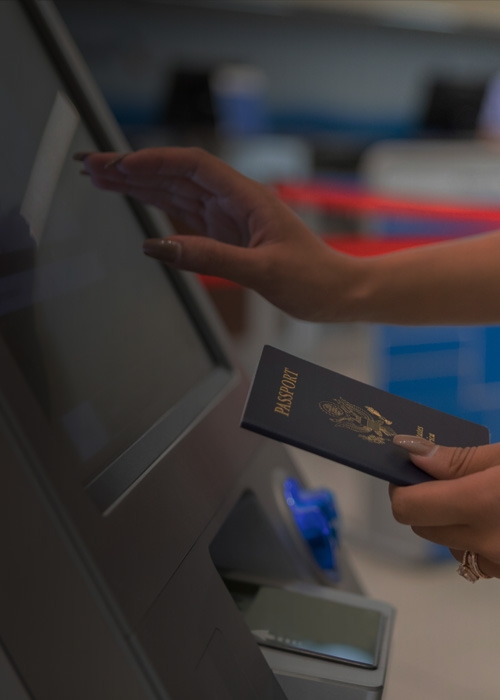 Woman holding passport using self-service airport kiosks